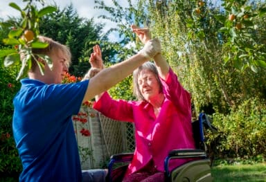 male care assistant helps female customer with physical exercises