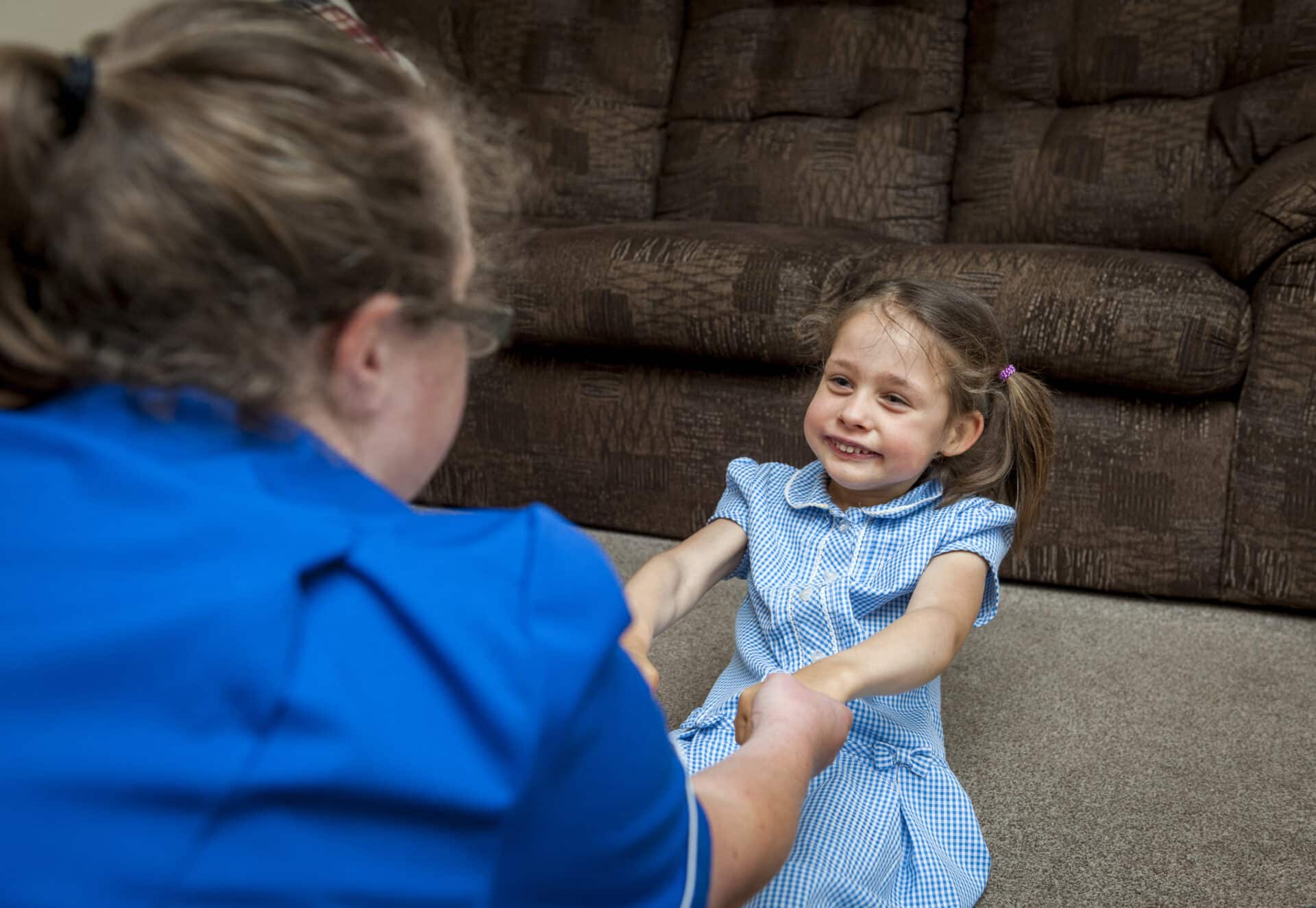 female care assistant playing with female customer during children's care