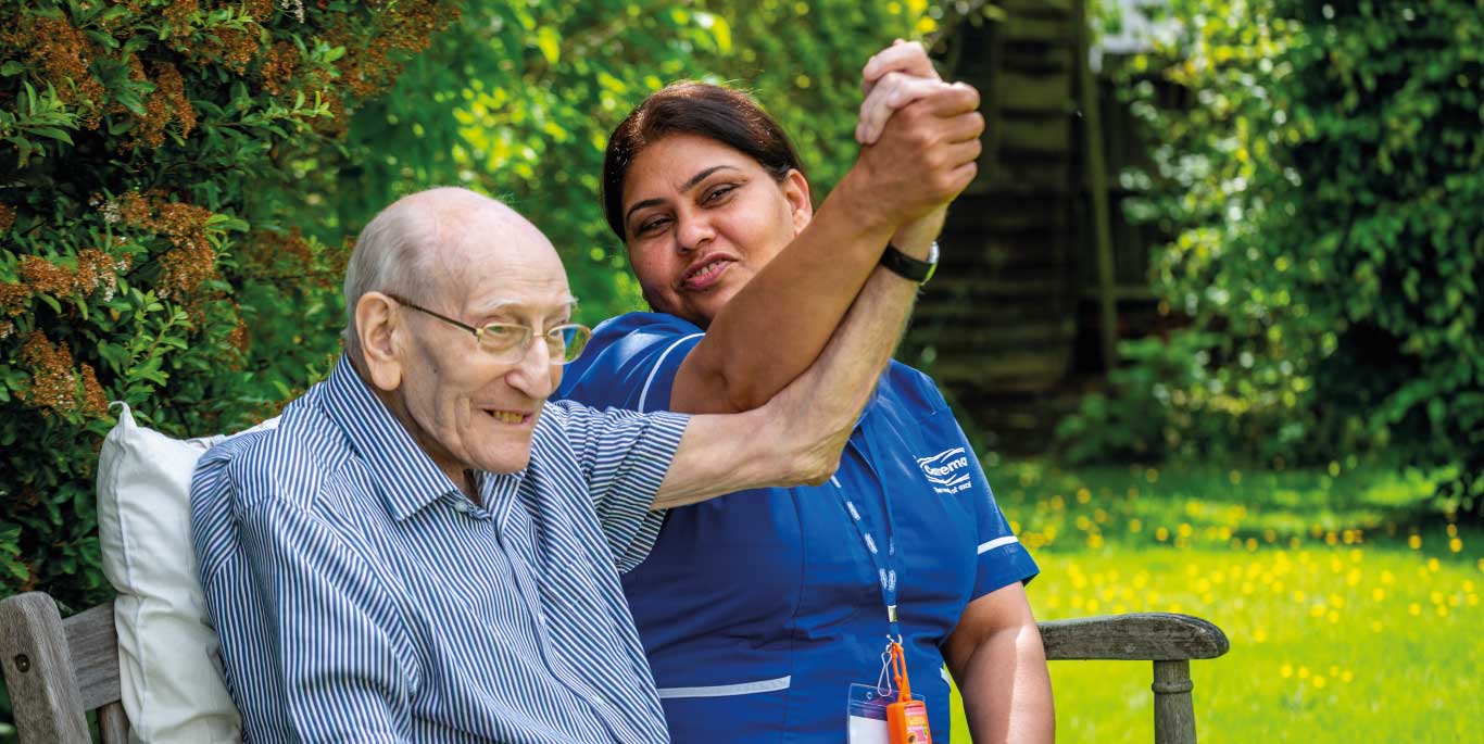 Man and care assistant raise their hands