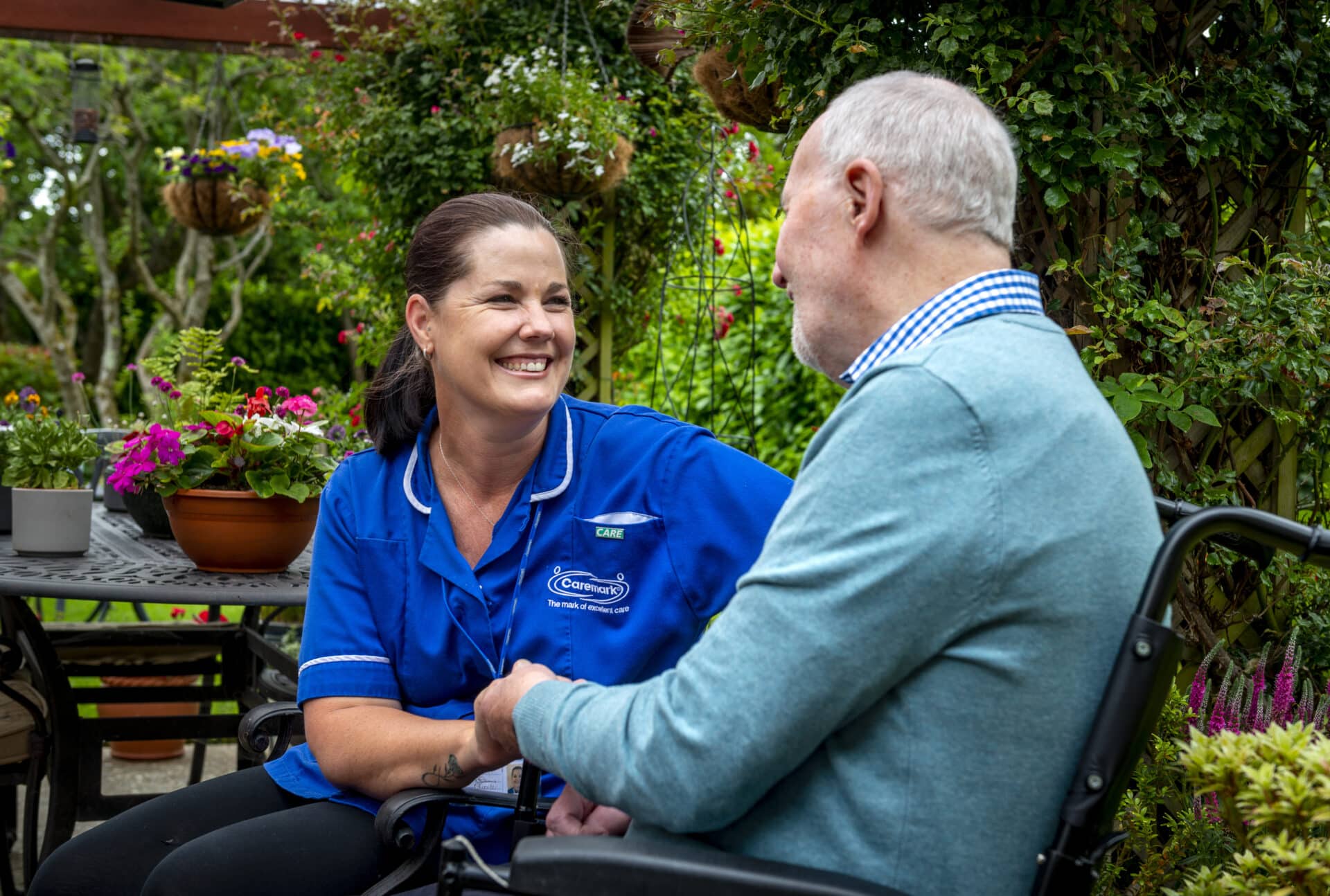 Carer and elderly man enjoying garden in Woking