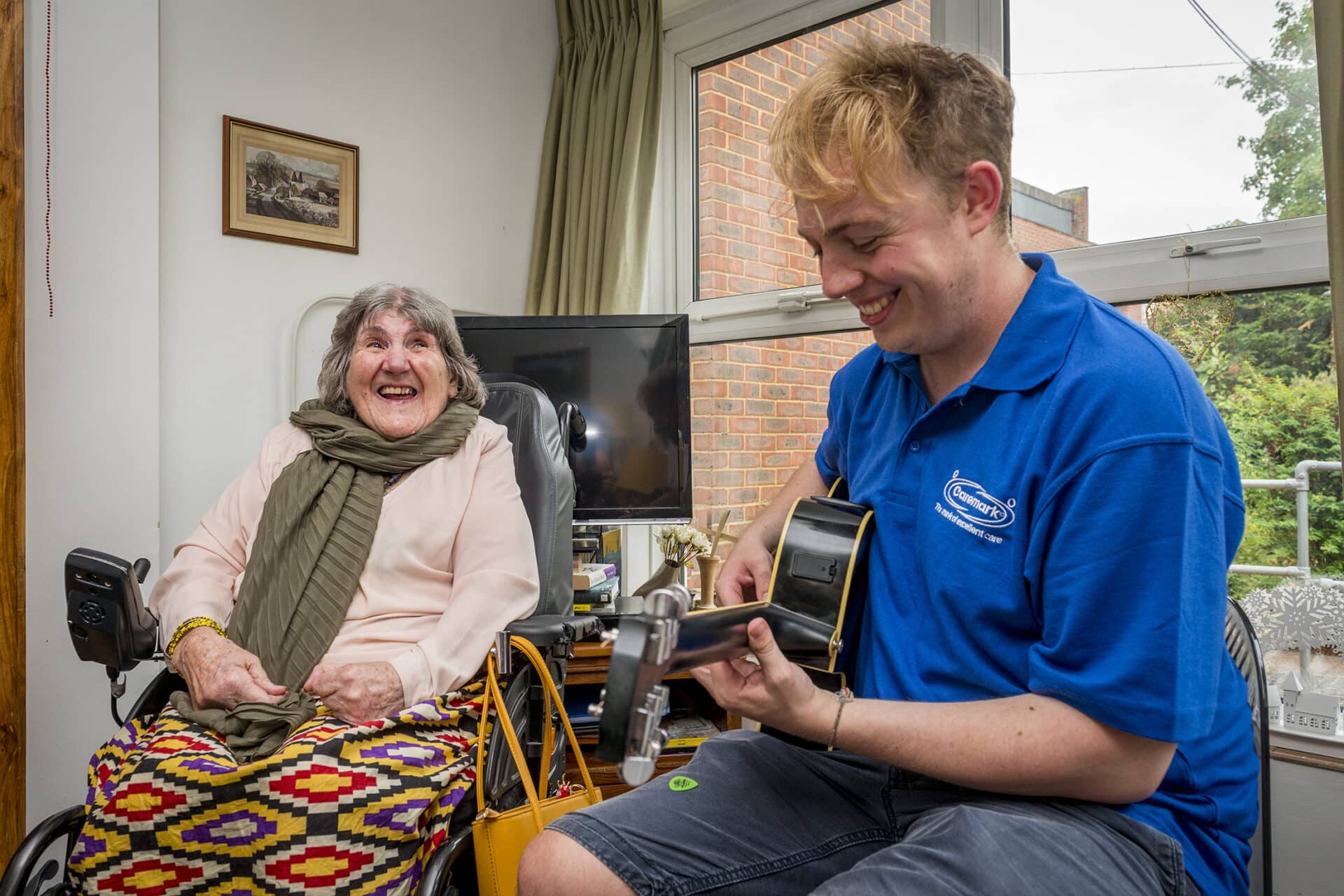 home care in Wandsworth: care assistant playing the guitar