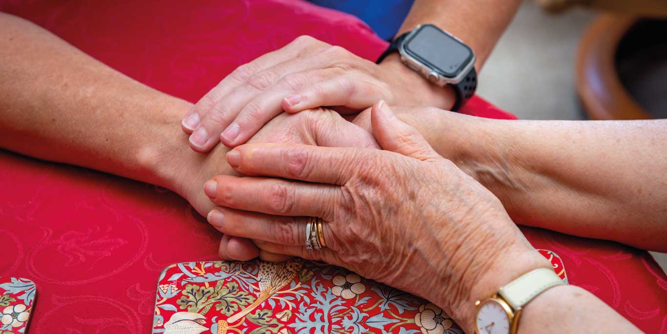 care assistant and customer holding hands