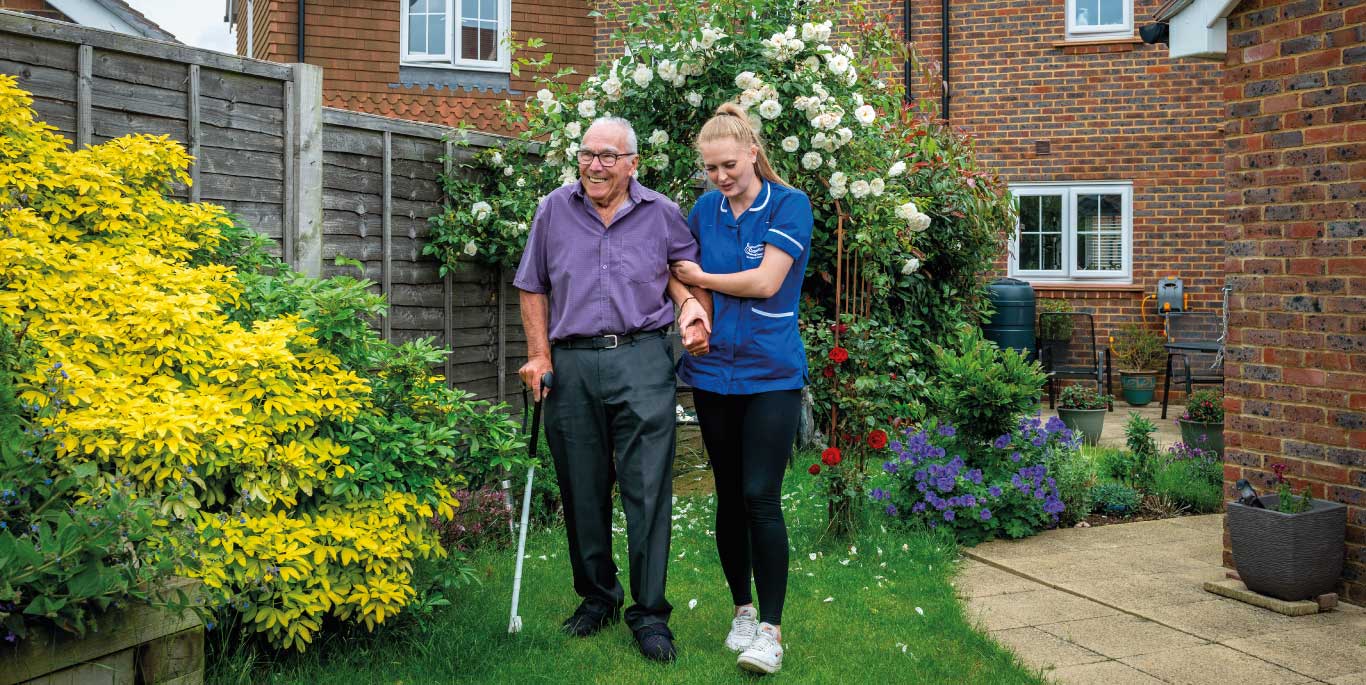 man with care assistant in garden