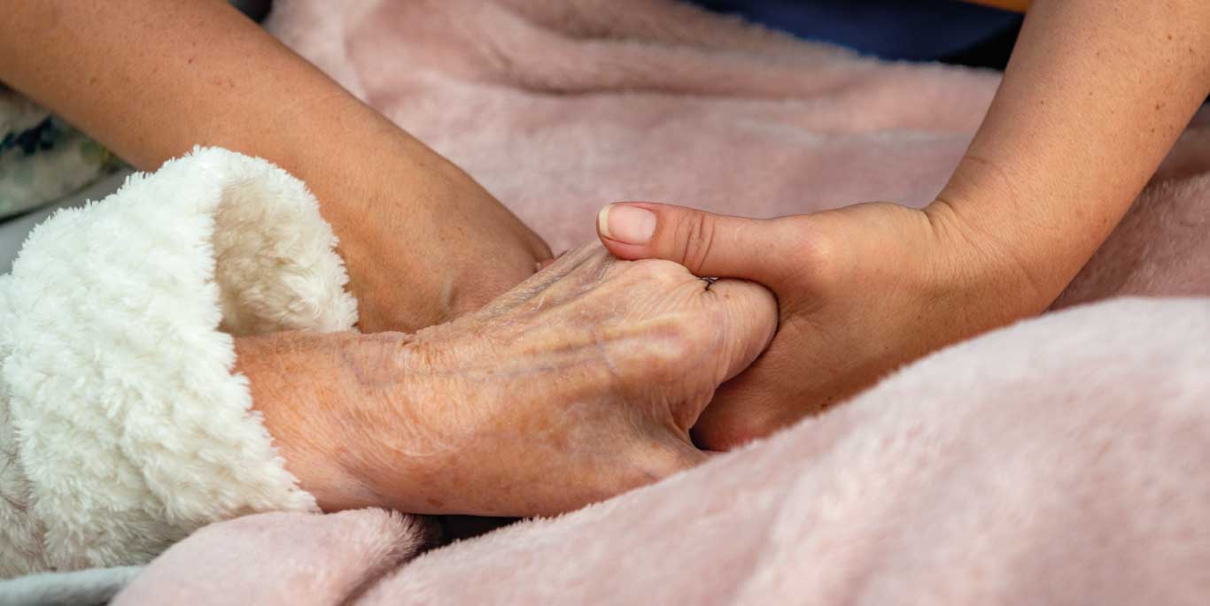 customer and care assistant holding hands