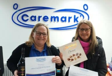 Two staff members smiling and holding their Employee of the Month awards in recognition of their outstanding achievements.