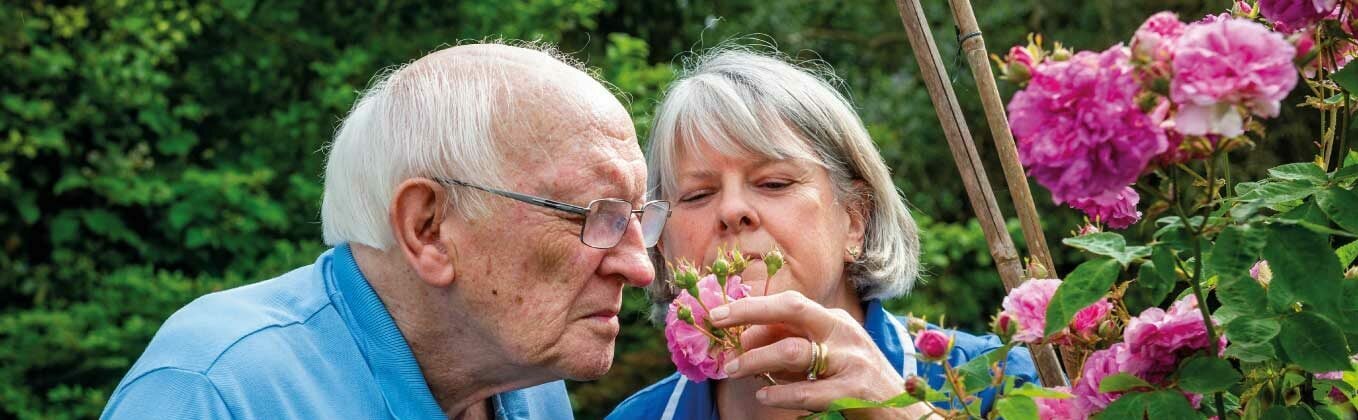 care assistant and customer smelling roses