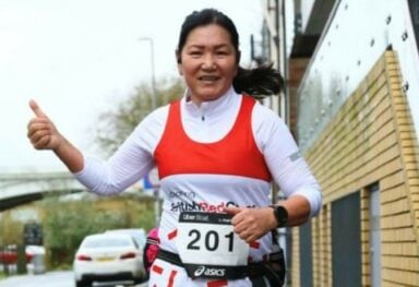 Image of a dedicated care assistant running in the London Marathon to support and raise funds for the British Red Cross Society, showcasing commitment to charitable causes and community service.