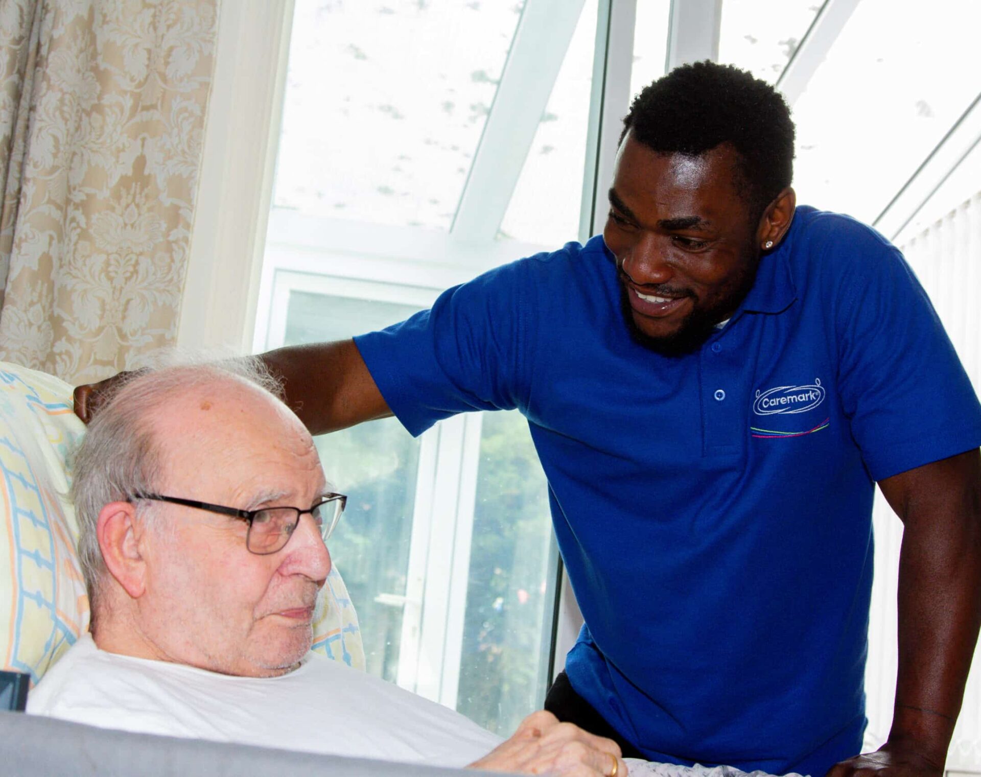 Care assistant and male customer who's in a bed