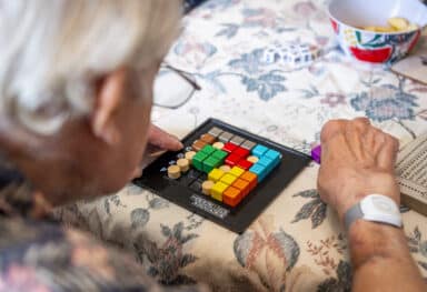 Customer challenging himself with a congestive puzzle game. In a friendly competition with the Care Assistant.  