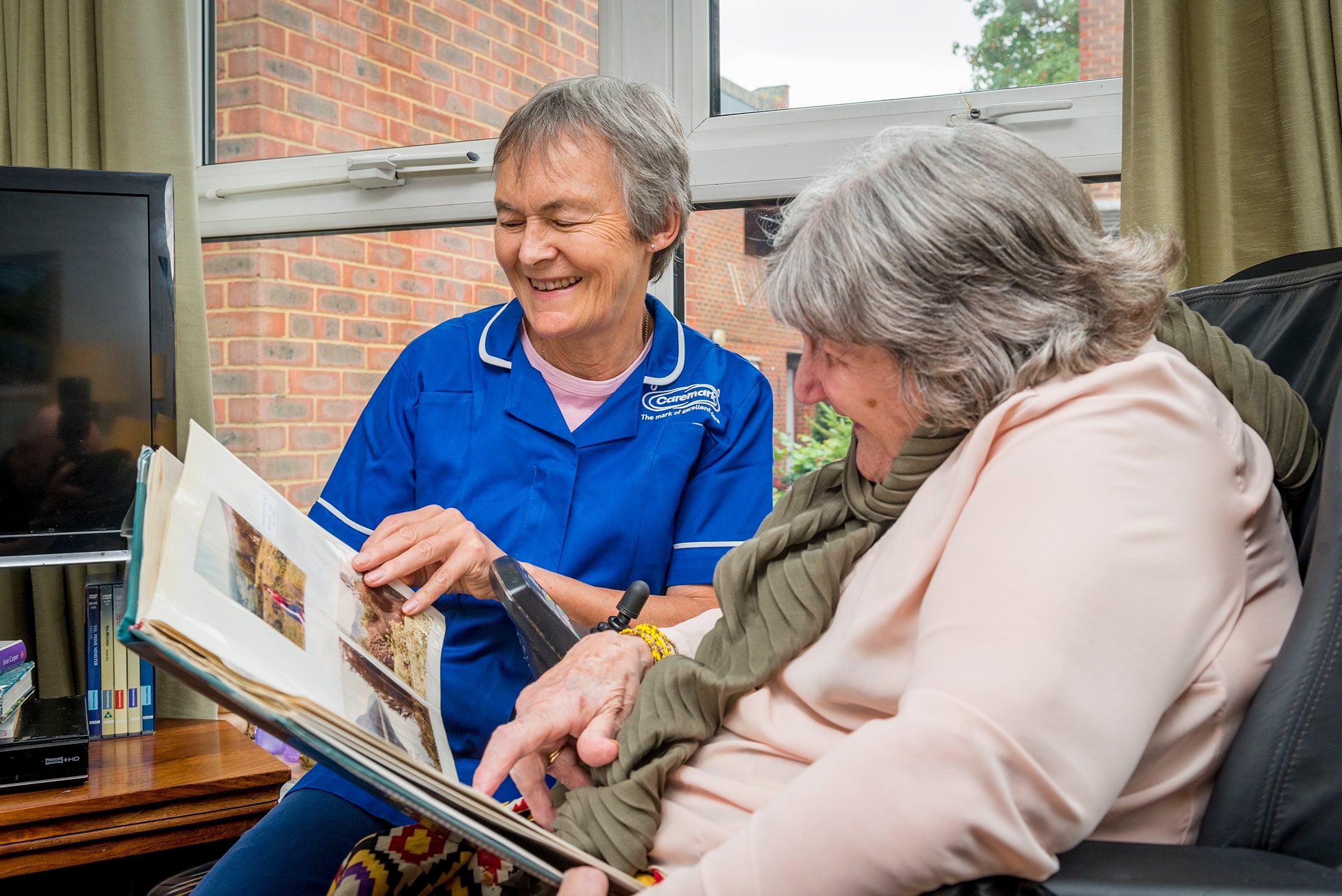 care assistant looking through a photobook with a female service user