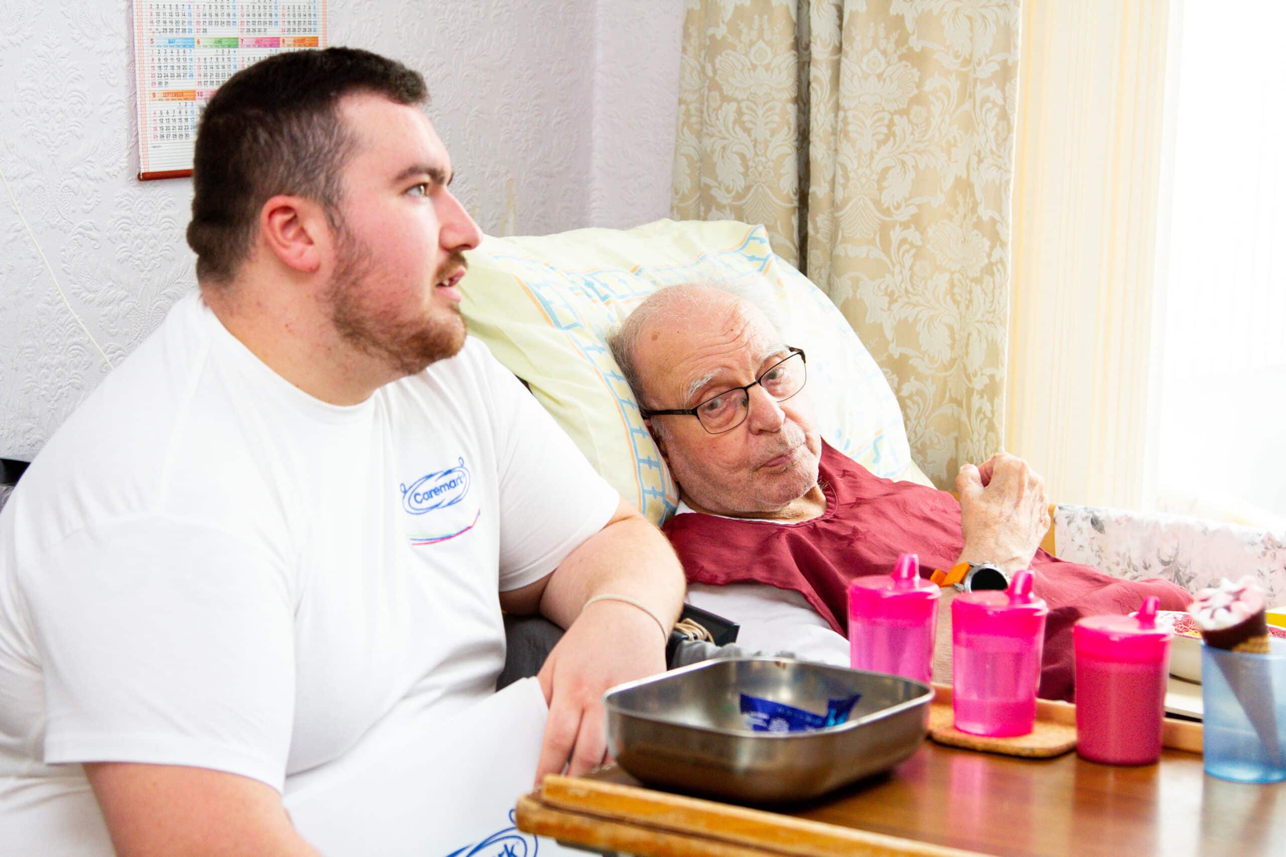 A carer watches TV and provides company