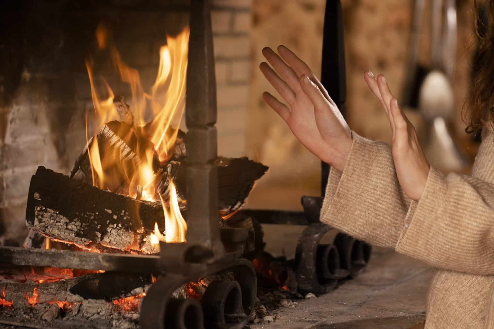 close up hands getting warm near fire