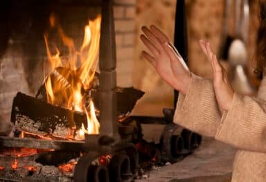close up hands getting warm near fire