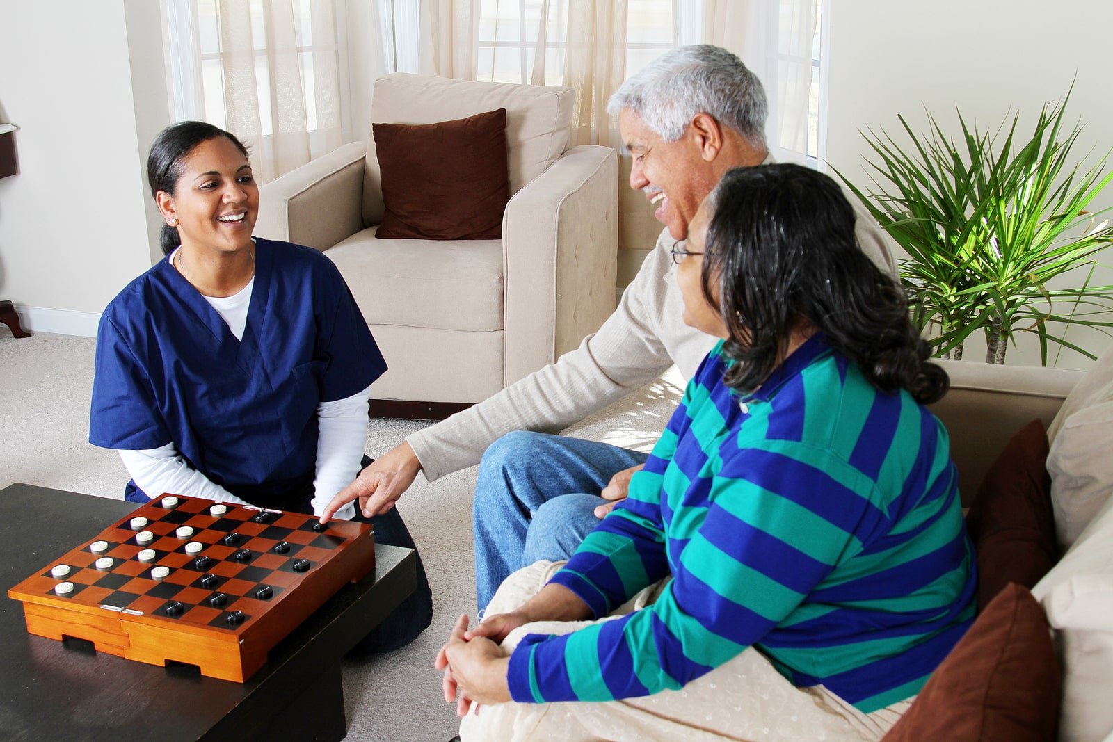 Home health care worker and an elderly couple playing game