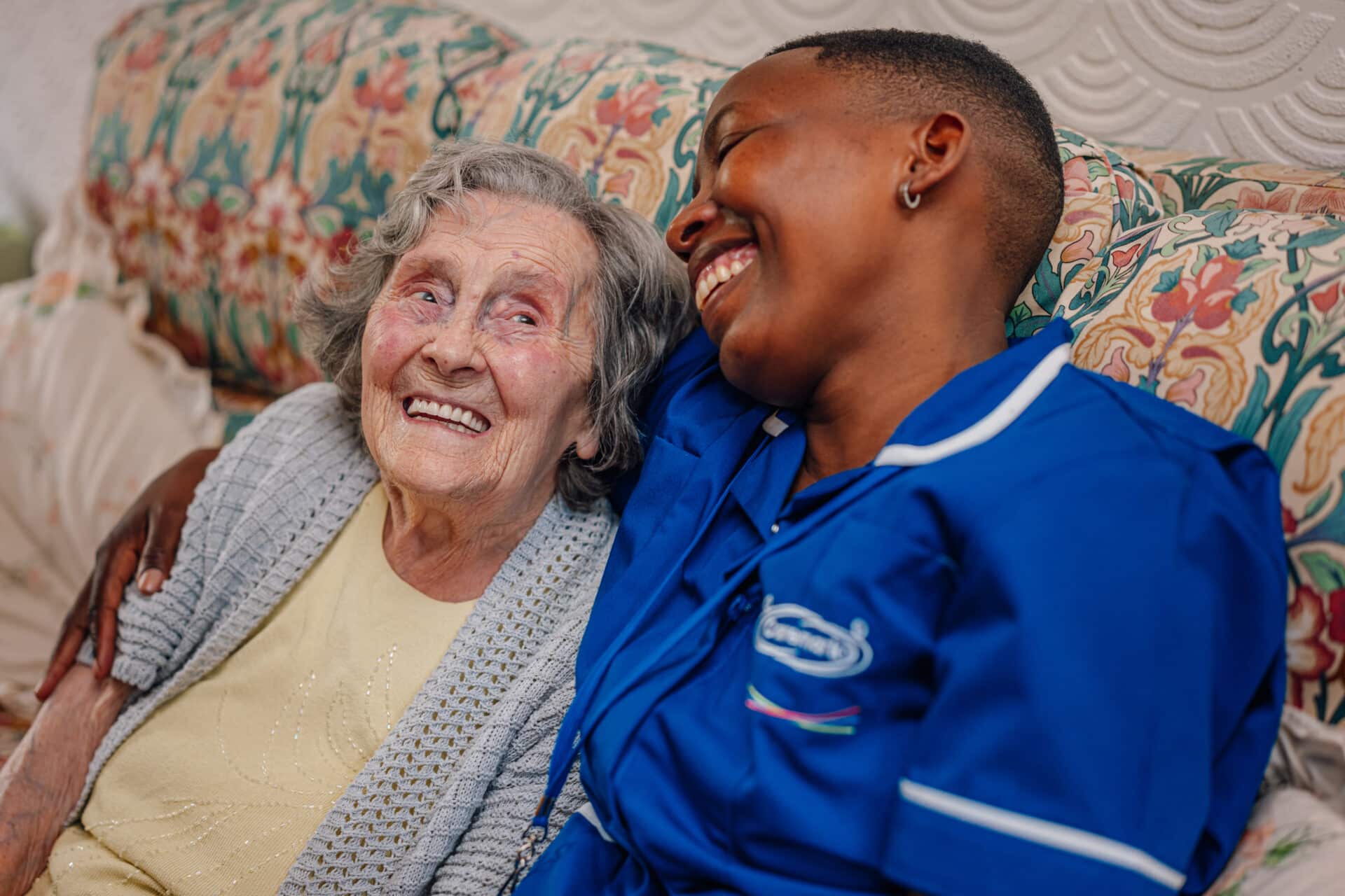 Care Assistant and customer are smiling as the customer is getting ready for night care