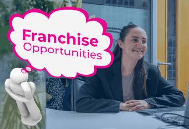 Caremark franchise team member smiling at a desk, with a pink thought bubble that reads “Franchise Opportunities”