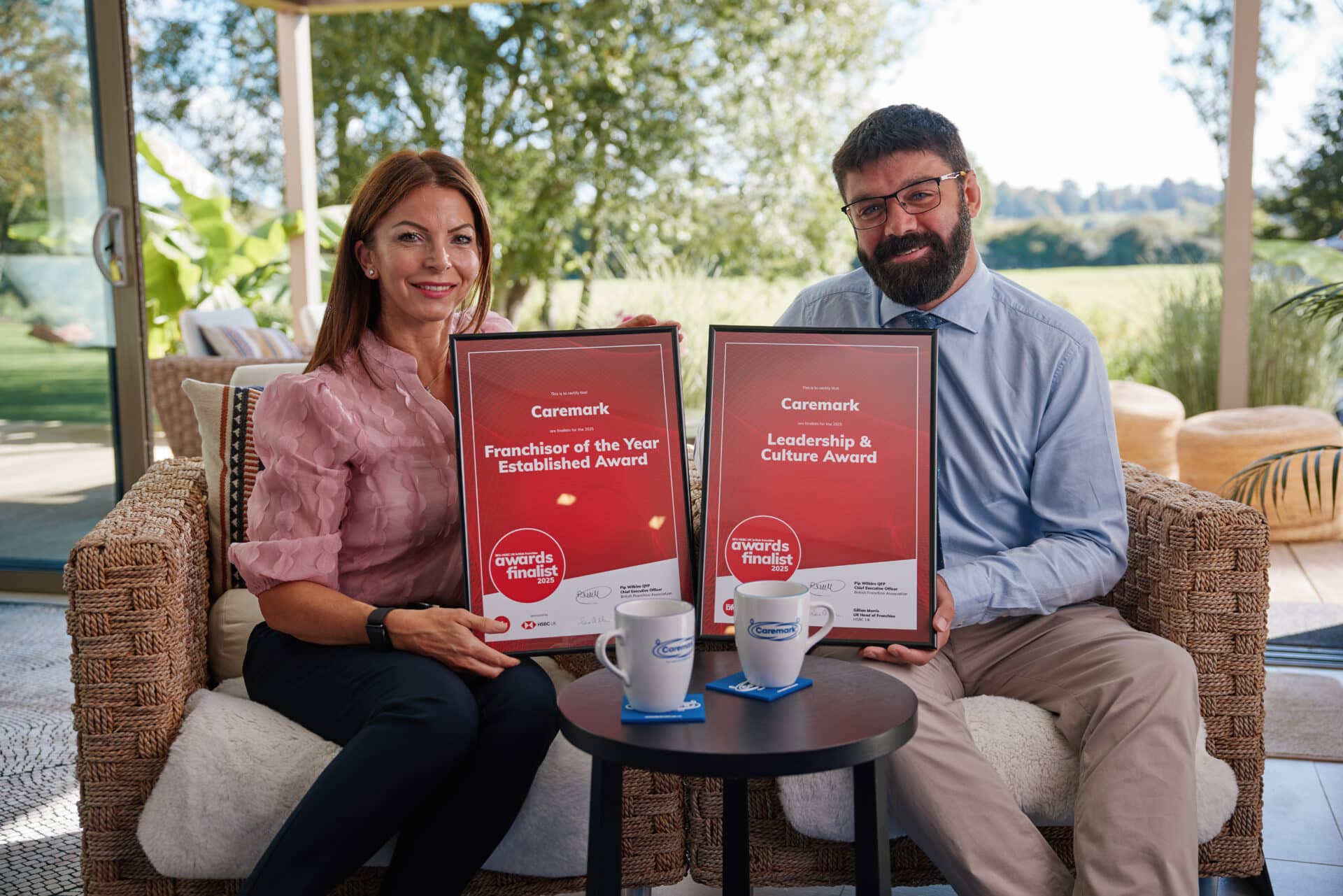 Two Caremark team members holding framed finalist certificates for the BFA HSBC British Franchise Awards 2025, recognising Caremark for Franchisor of the Year and Leadership & Culture.