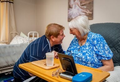 Caremark North Herts and Stevenage live-in care assistant helping an elderly client at home with daily activities and companionship.