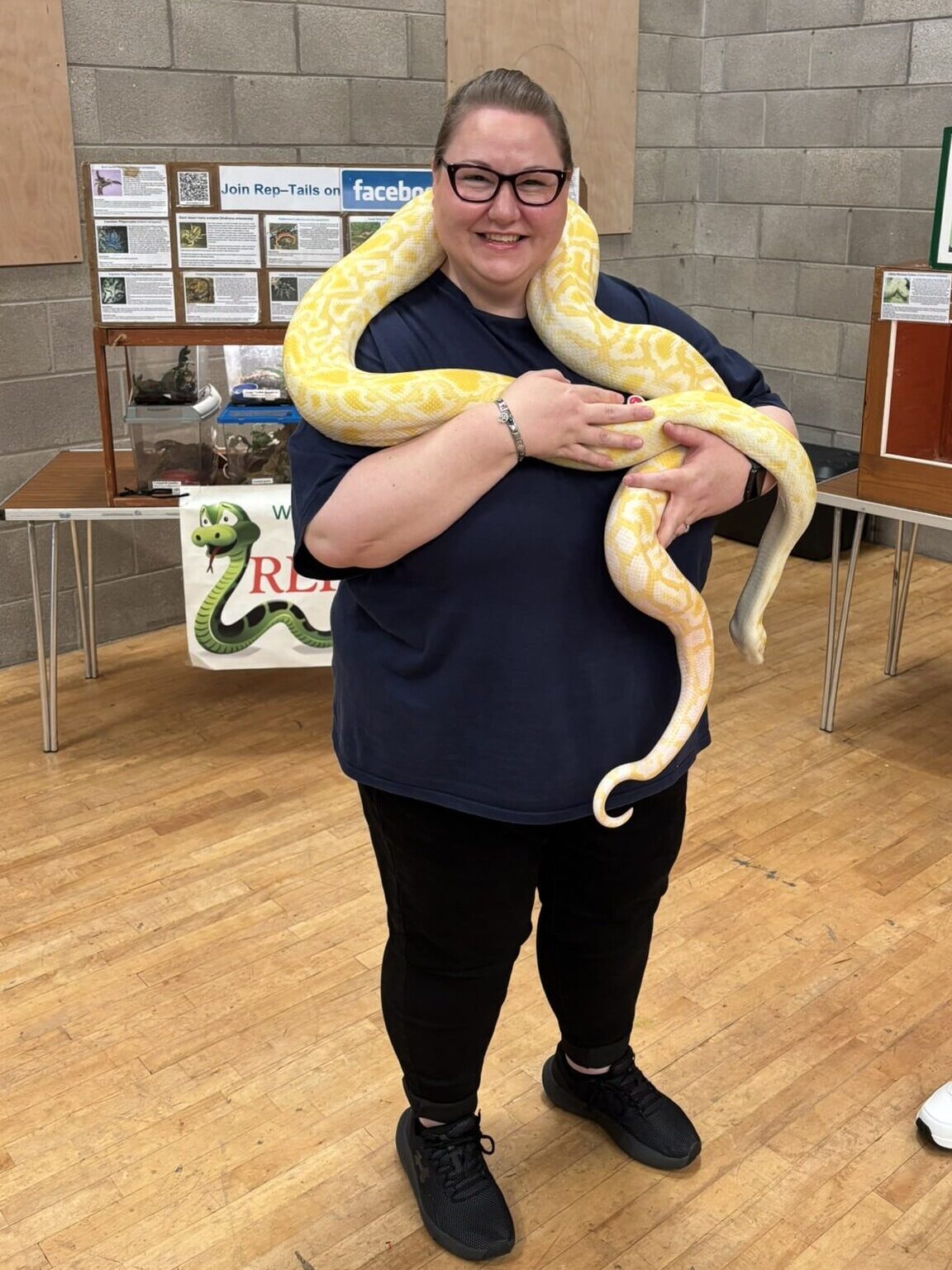 Lyndsay smiling with a snake around her neck during the Caremark NI family fun day reptile activity