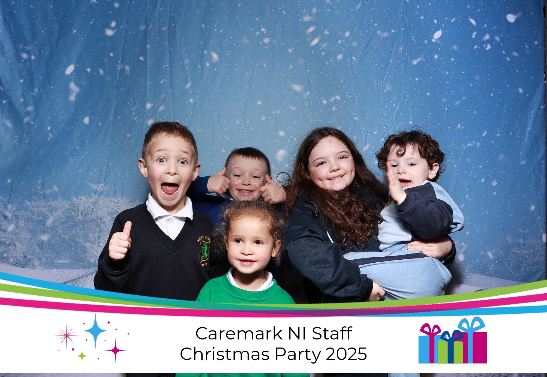 Five children smiling and posing together in a photo booth