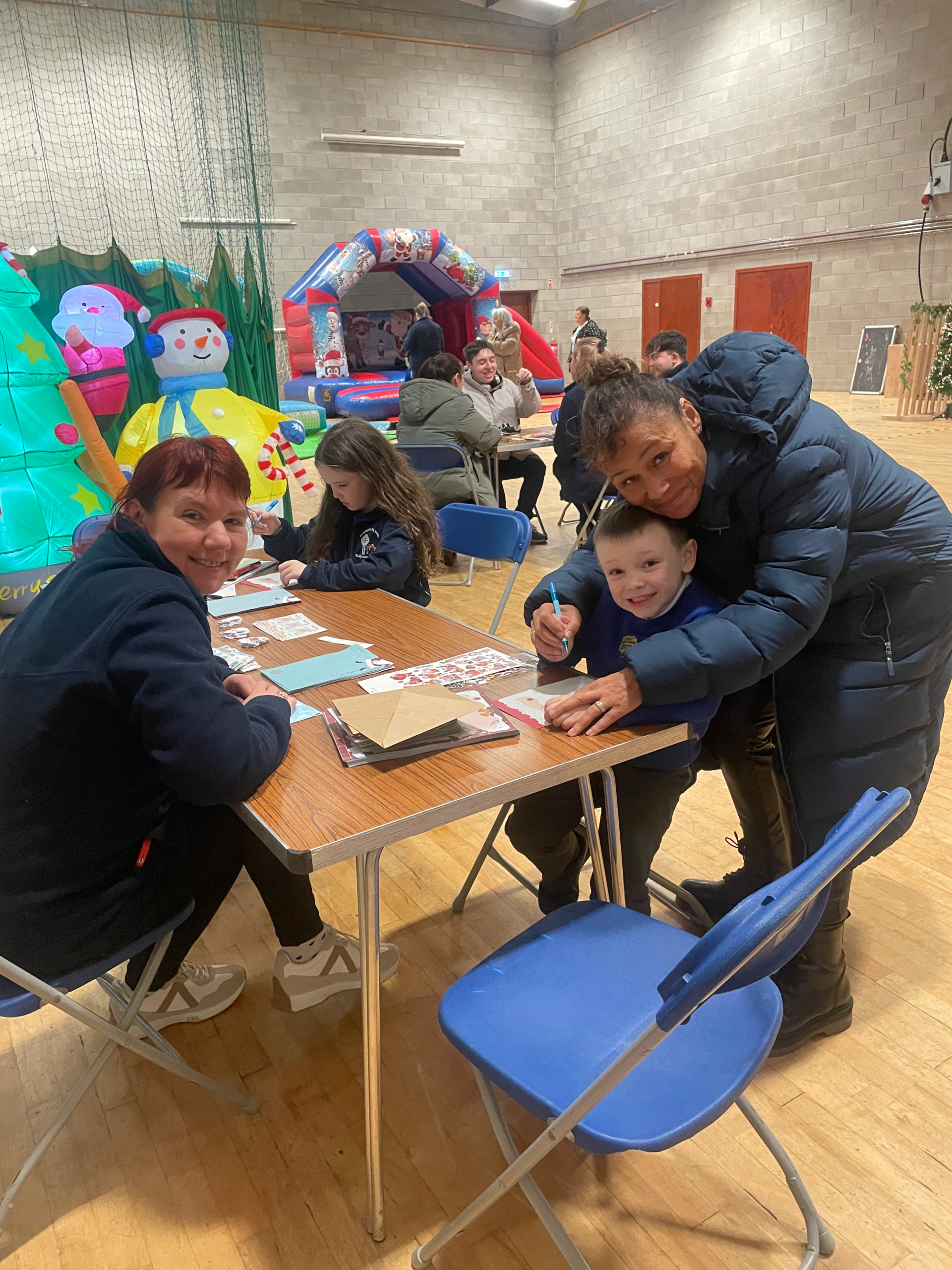 A young boy sitting at a table, colouring in