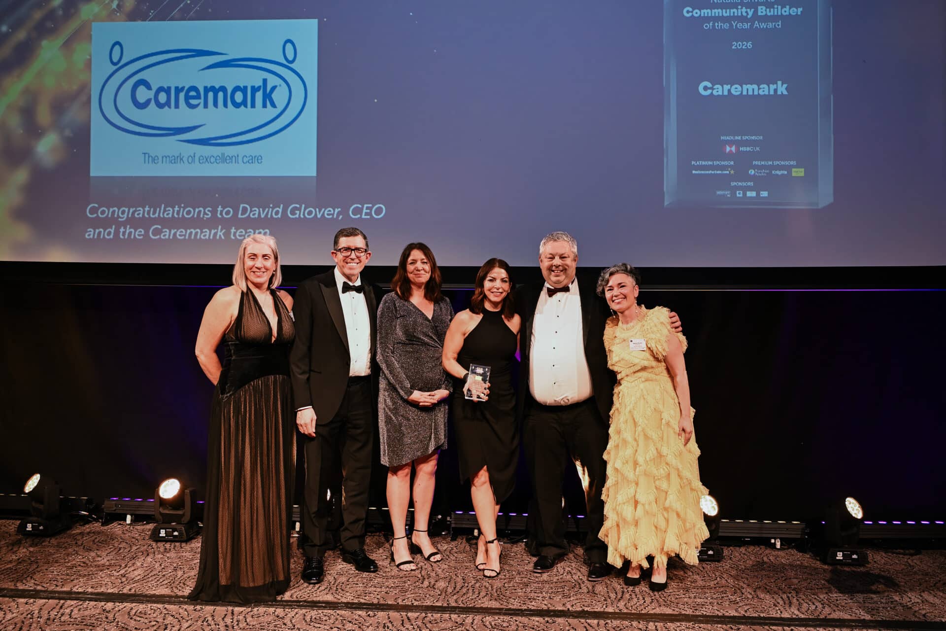 Caremark team members pose on stage at the Elite Franchise Top 100 Awards 2026 after winning the Natalia Shvarts Community Builder of the Year award. A great franchise example