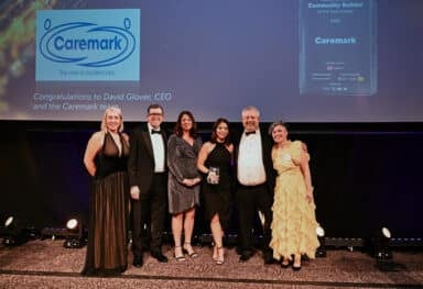 Caremark team members pose on stage at the Elite Franchise Top 100 Awards 2026 after winning the Natalia Shvarts Community Builder of the Year award. A great franchise example