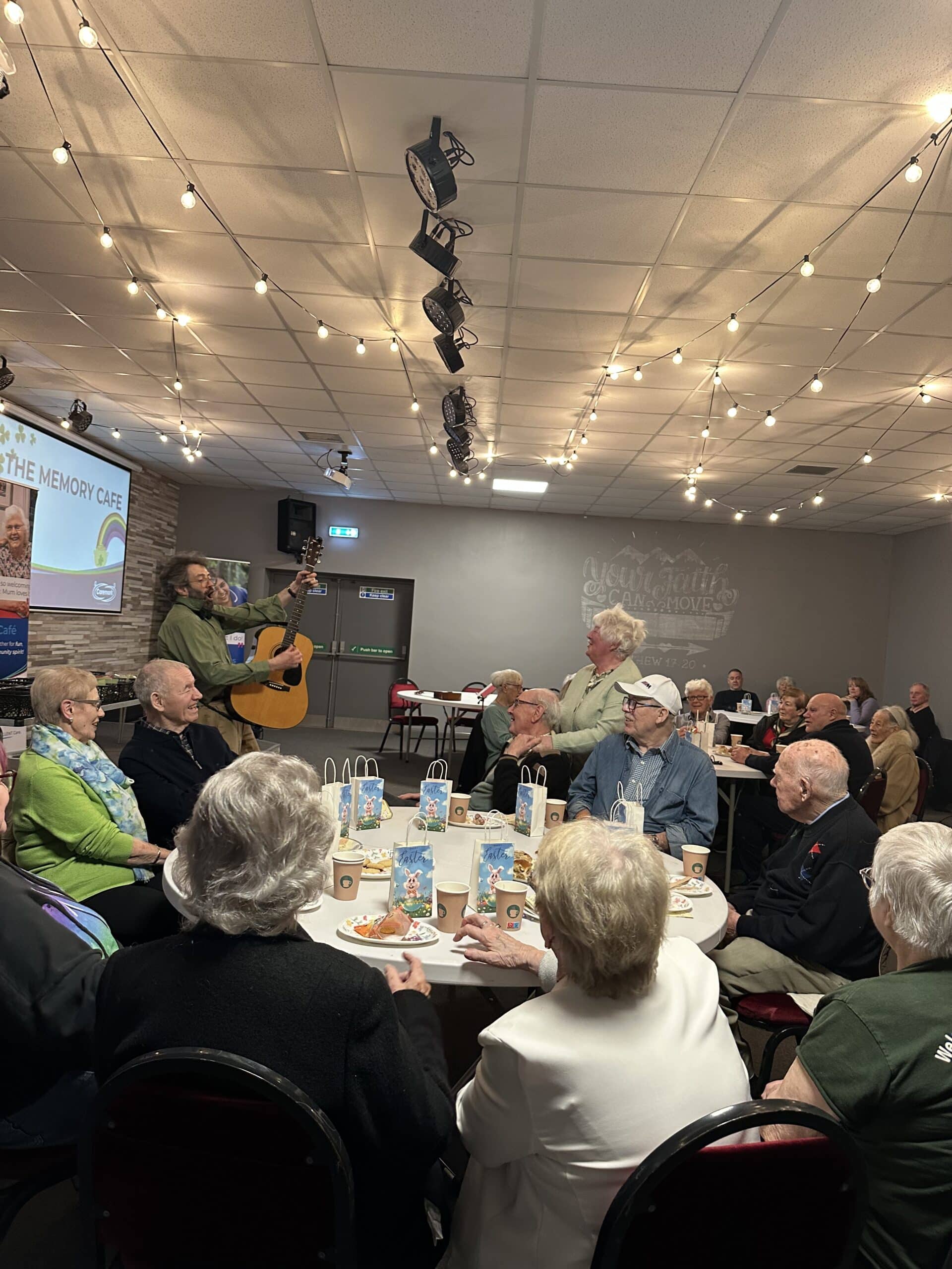 Service users sitting together at tables enjoying the March Memory Cafe