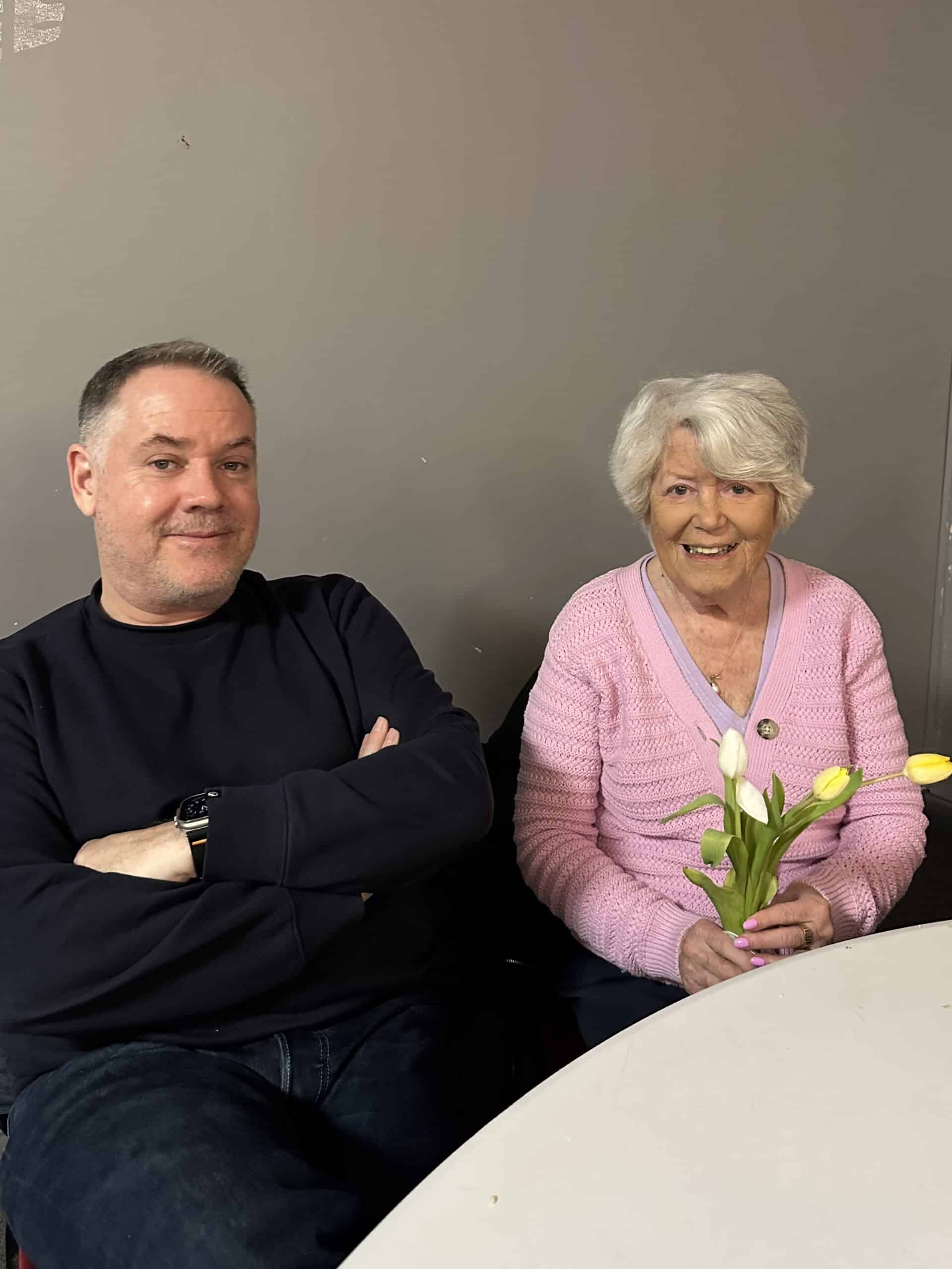 Service users smiling while holding a bunch of tulips March Memory Cafe