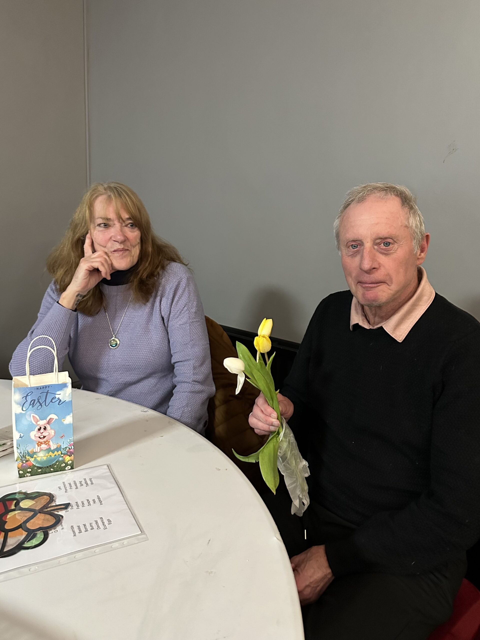 Service users smiling while holding a bunch of tulips March Memory Cafe
