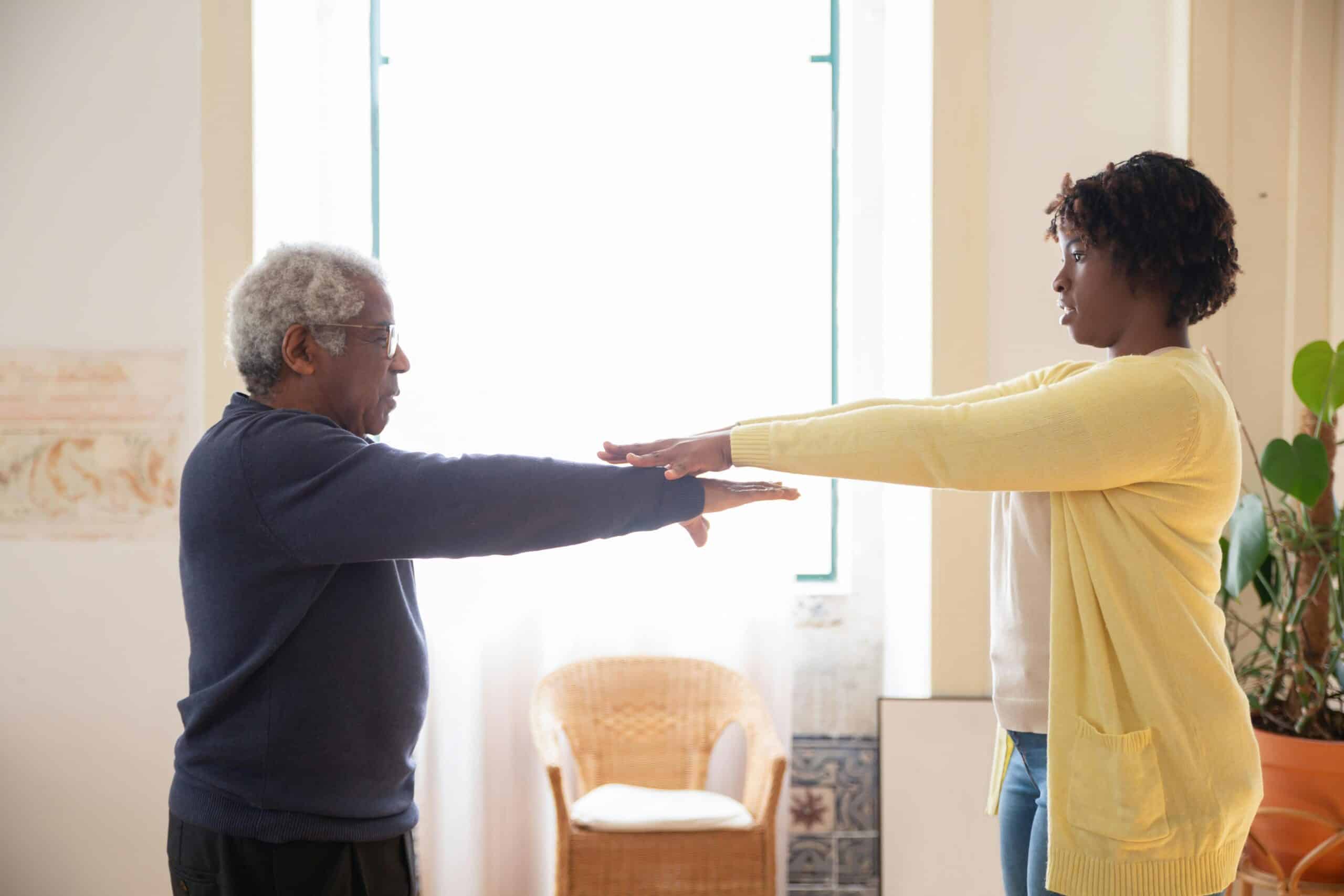 Male customer exercising with female carer to prevent falls