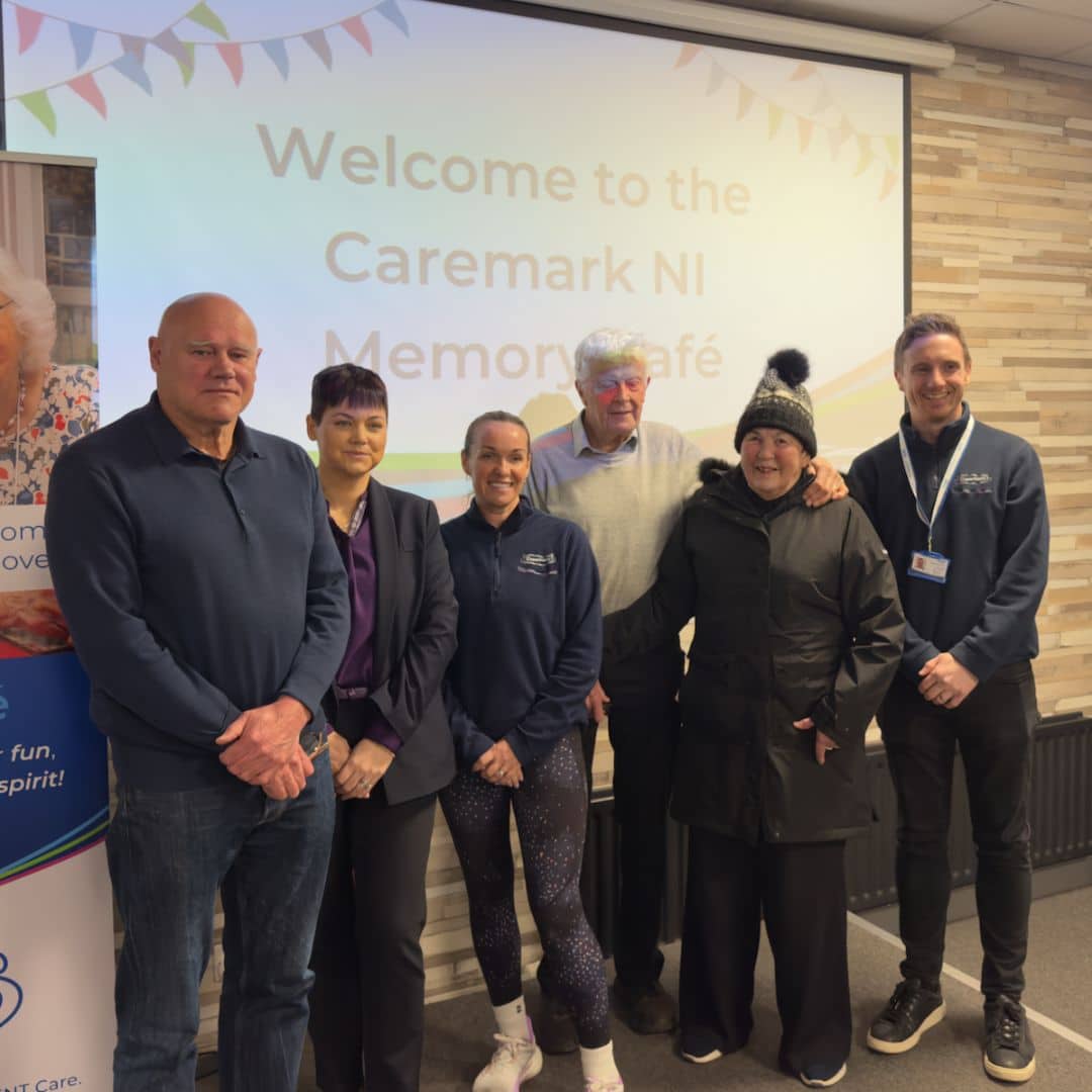 Staff and service users smiling together at the Memory Cafe
