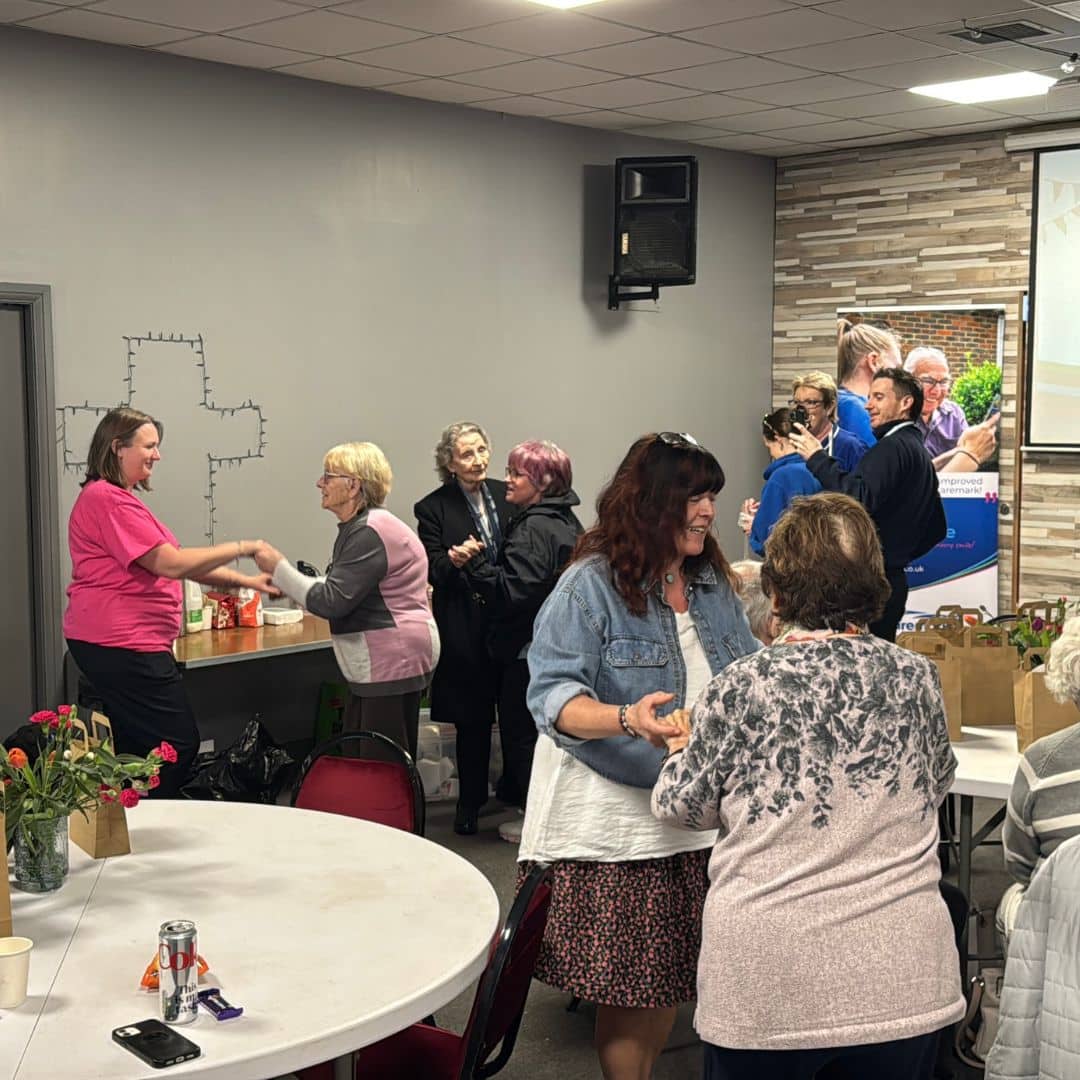 Service users smiling and dancing together at the Memory Cafe