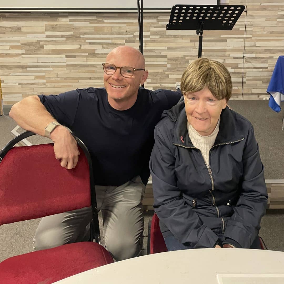 Two people smiling together during the Memory Cafe session