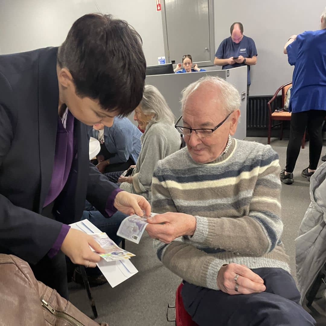 Ulster Bank employee showing a service user examples of counterfeit money at the Memory Cafe