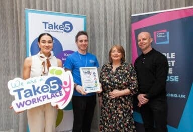 Christopher, Caremark NI Wellbeing Manager, pictured with representatives from partner organisations at the wellbeing accreditation event