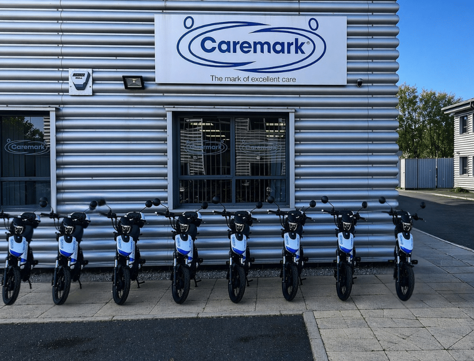 8 Caremark e-bikes parked outside of the office