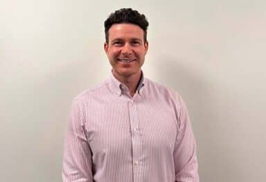 Caremark Swansea franchise owner smiling in a striped shirt against a plain background.