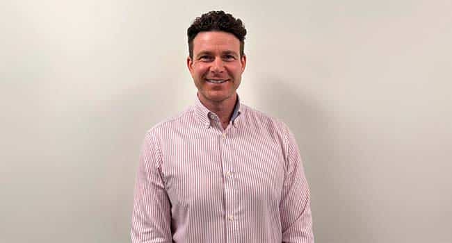 Caremark Swansea franchise owner smiling in a striped shirt against a plain background.