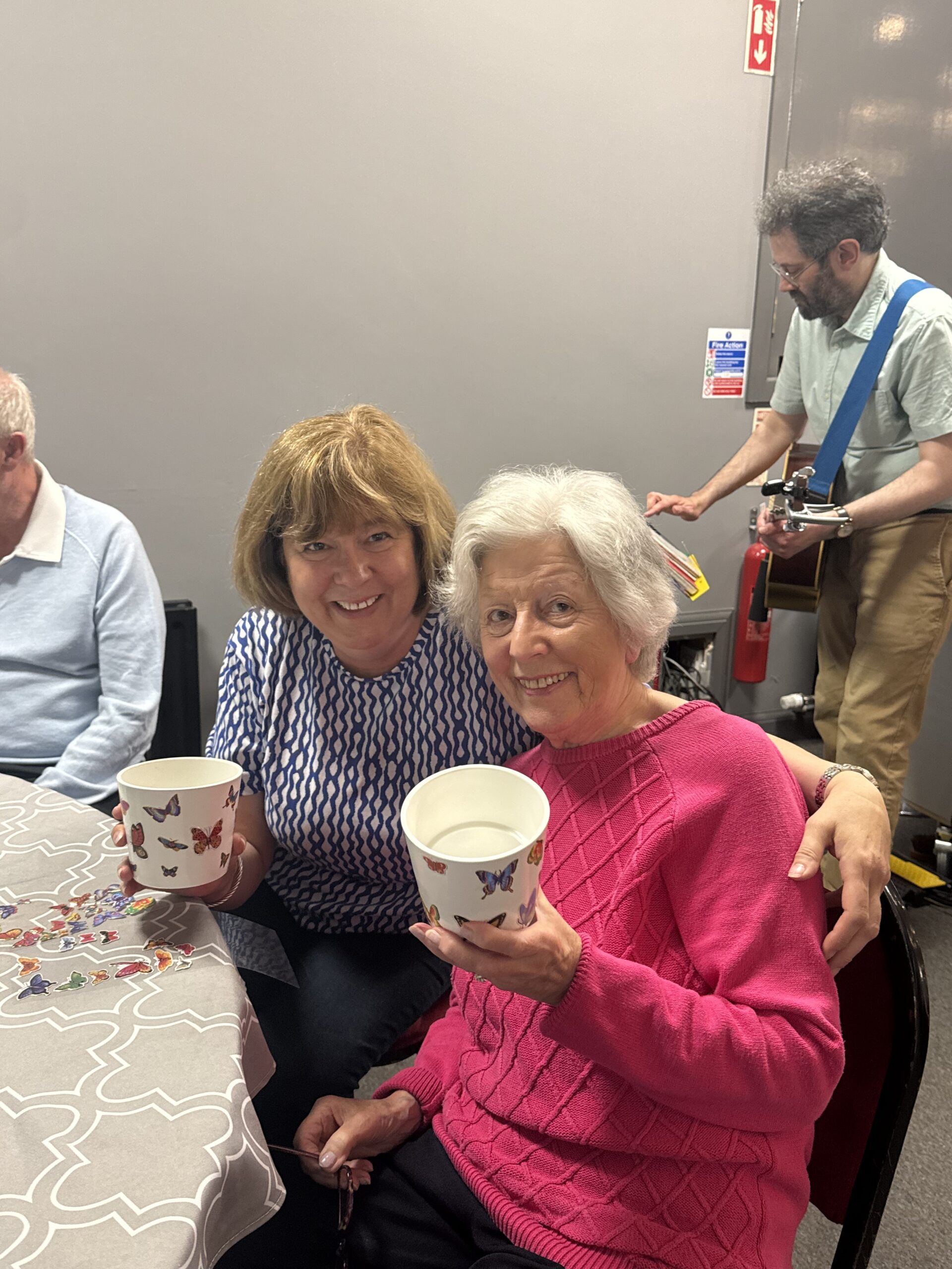 two service users holding up their decorated plant pots