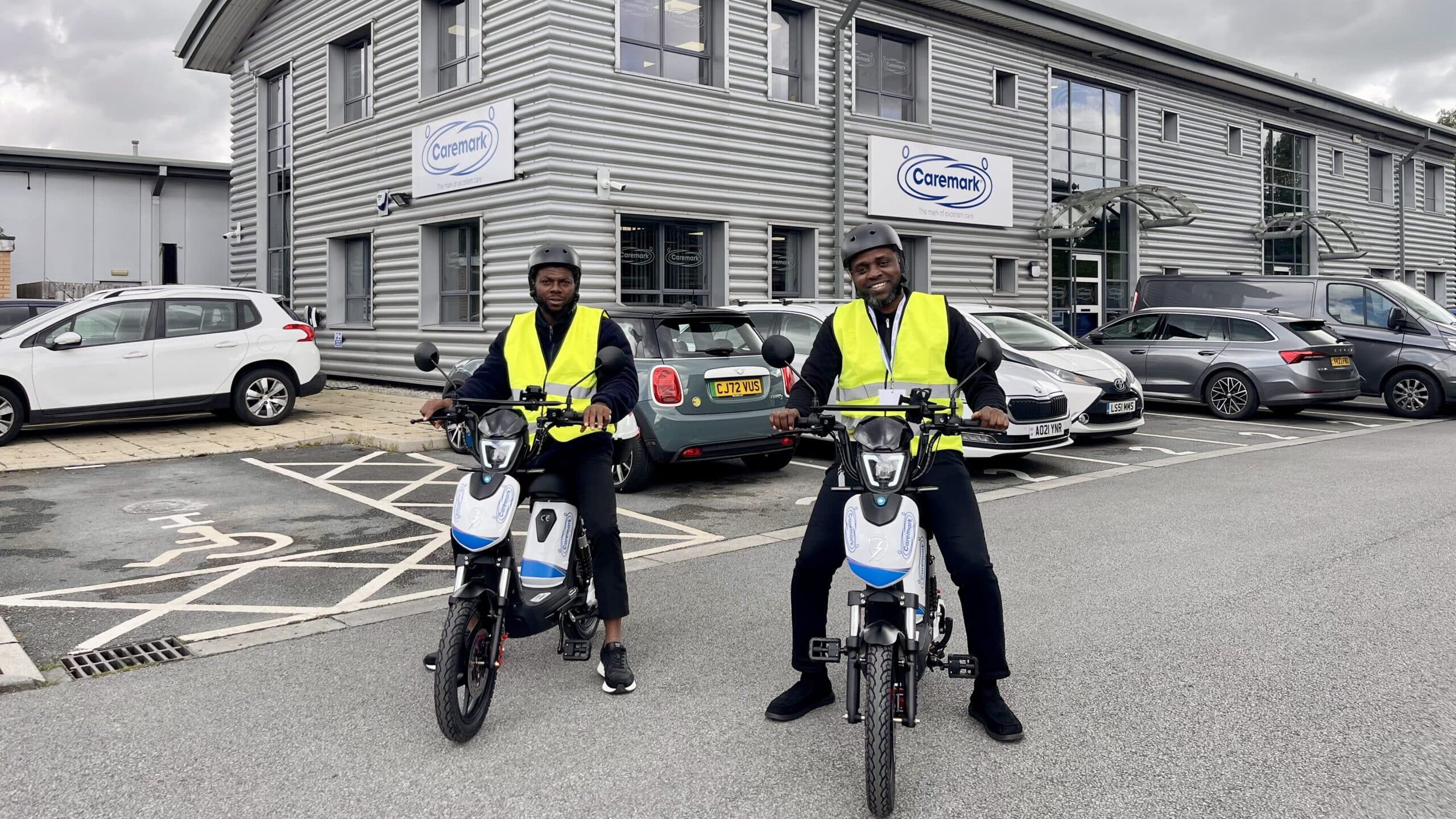 two male care assistants on the company e-bikes