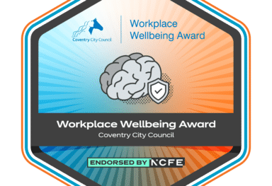 Workplace Wellbeing Award badge from Coventry City Council. The hexagonal badge features the Coventry City Council logo, the words 'Workplace Wellbeing Award', an illustration of a brain with a shield symbolising mental health and wellbeing, and the text 'Endorsed by NCFE' at the bottom.
