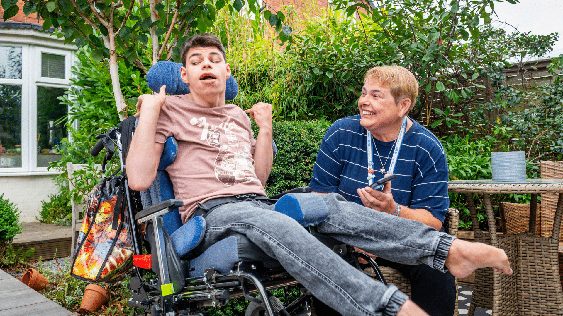 male customer enjoying the day, smiling in the garden with female care assistant, promoting companionship at home.