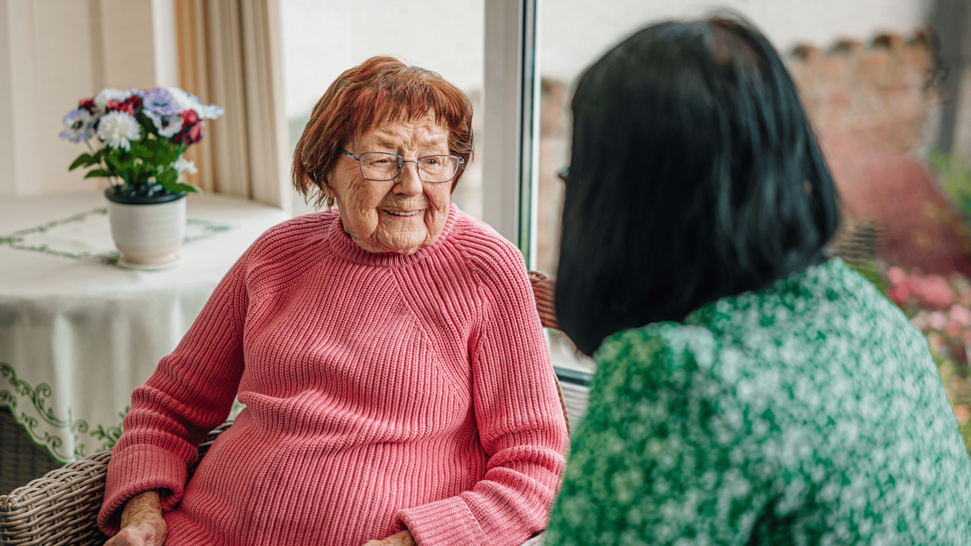 Female customer chatting and smiling with a loved one at home, representing support options for families in North Lincolnshire.