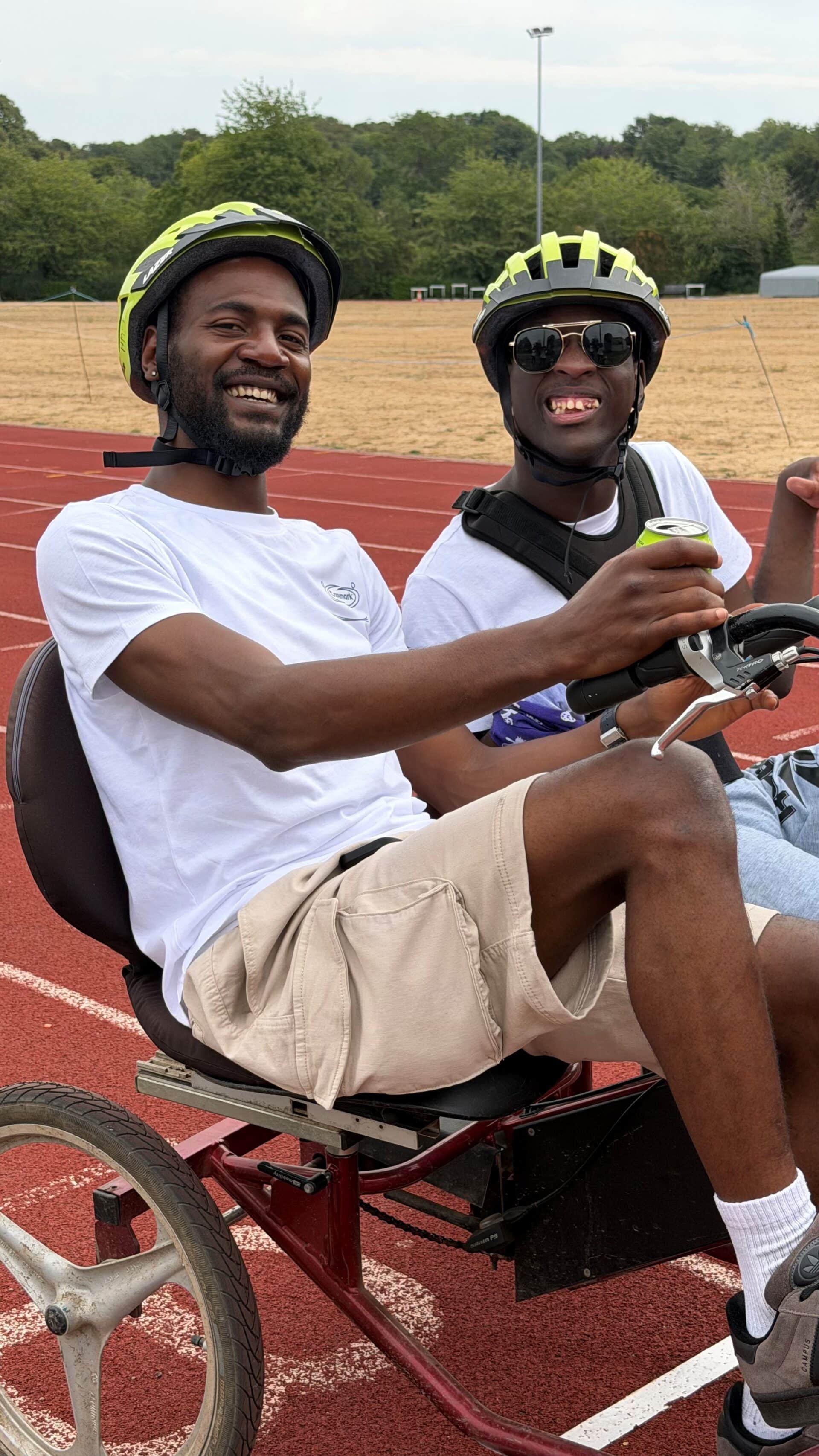 Kudzai with Caremark North Herts and Stevenage Care Assistant cycling the 400m track at Ridlin's Athletic Stadium in Stevenage.