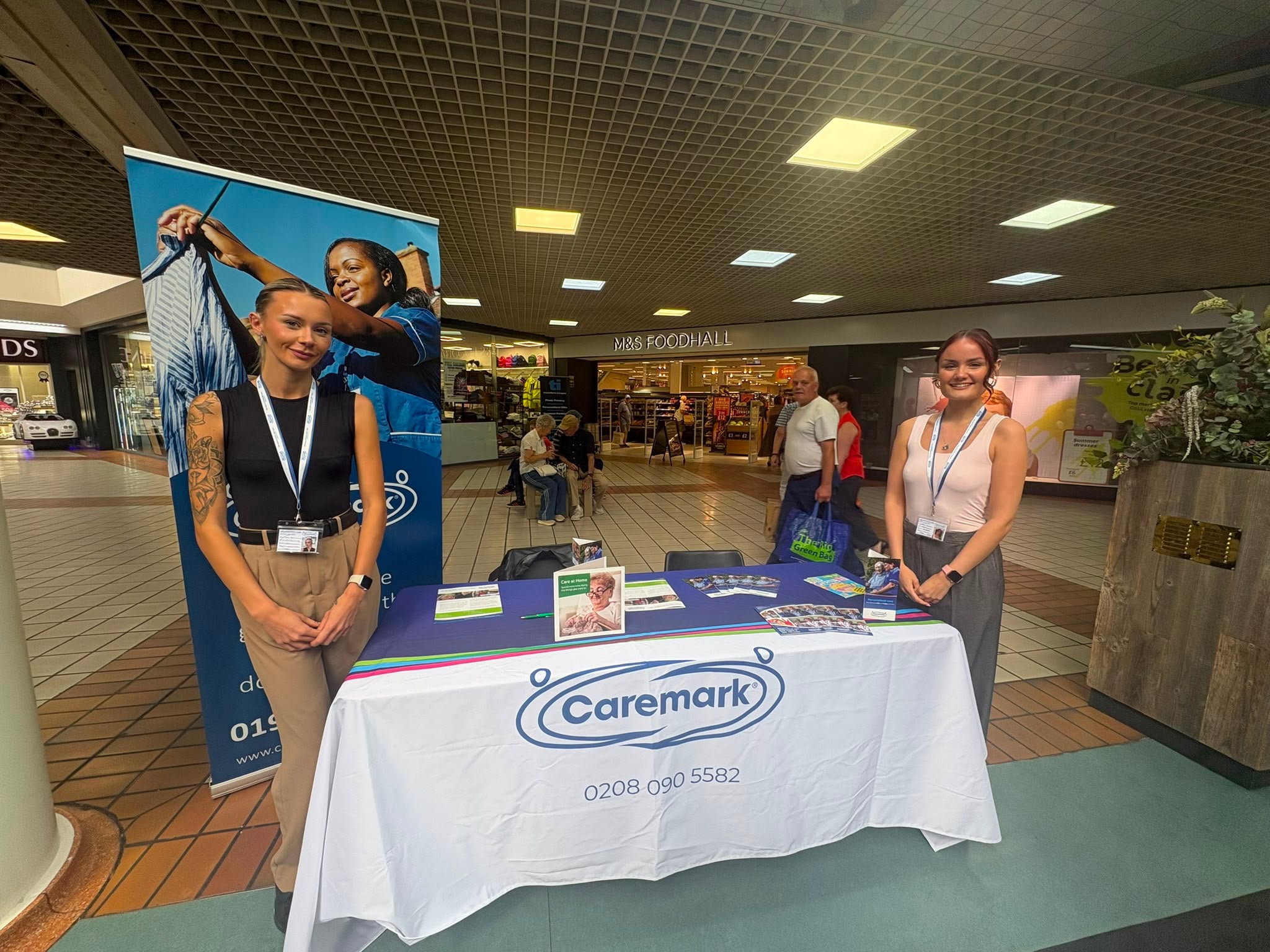 Millie and Alice from Caremark Wakefield sharing information about community support in Wakefield at an Age UK event.