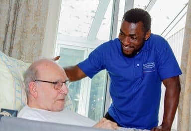 smiling male care assistant with male customer ()